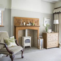 a living room filled with furniture and a fire place next to a window covered in curtains