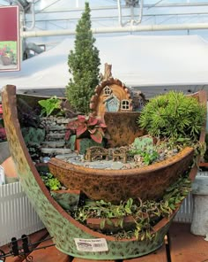 a boat shaped planter is on display at a garden show in an indoor setting