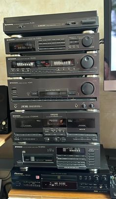 a stack of stereos sitting on top of each other in front of a tv