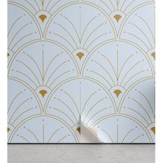 an art deco wallpaper with gold and white fan pattern on the back, against a light blue background