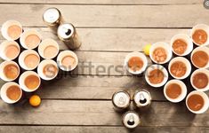 there are many cups that have different types of drinks in them on the wooden table