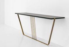 a black and gold console table with metal bars on the top, against a white wall