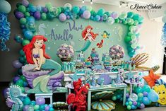 the little mermaid birthday party is set up with balloons, decorations and table cloths