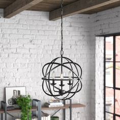 a chandelier hanging from the ceiling in a room with white brick walls and wooden beams