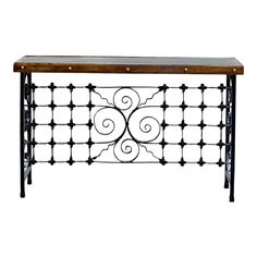 an iron and wood console table with scroll work on the top, against a white background