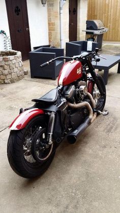 a red and black motorcycle parked in front of a building