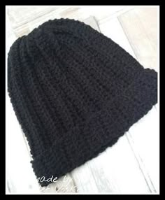 a black knitted hat sitting on top of a wooden floor