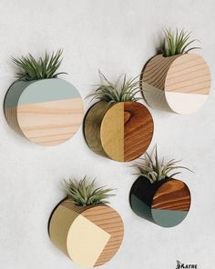 four air planters with different shapes and colors on the top one is made out of wood