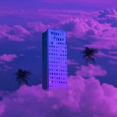 a tall building surrounded by clouds and palm trees