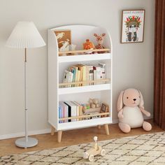 a white book shelf sitting next to a lamp