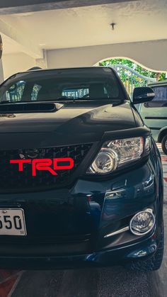 the front end of a black car parked in a garage