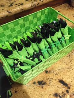 a green basket filled with black and green paper stars on top of a marble counter