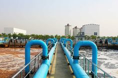 blue pipes are lined up on the side of a dock