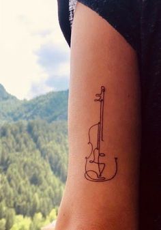 a woman's arm with a violin tattoo on the left side of her body