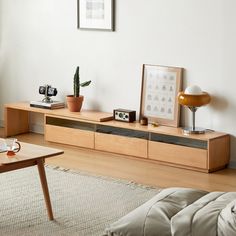 a living room with a couch, table and pictures hanging on the wall next to it