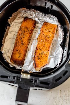 two pieces of fish sitting in an air fryer