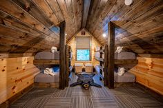 there are three bunk beds in this small room with wood walls and flooring on both sides