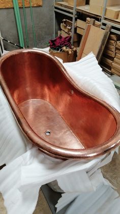 an old copper bathtub sitting on top of a pile of toilet paper