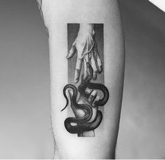 a black and white photo of a person's arm with a snake on it