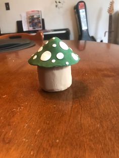 a small green mushroom sitting on top of a wooden table