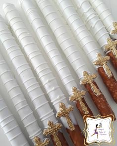 there are many white candles with gold crosses on them