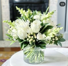 a vase filled with white flowers on top of a table