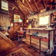 a room filled with lots of clutter and furniture next to a wooden wall covered in pictures