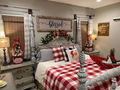 a bedroom decorated for christmas with plaid bedding and holiday decorations on the wall above the bed