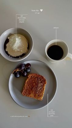 a plate with bread, grapes and coffee on it