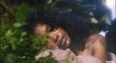 a woman laying in the grass with her eyes closed