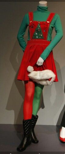 two mannequins dressed in christmas themed clothing, one holding a white cat