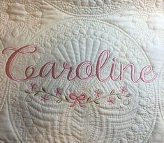 a close up of a quilt with the word careline on it and an embroidered design