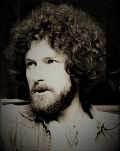 a black and white photo of a man with curly hair