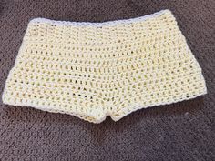 a crocheted white shorts is laying on the floor next to a gray carpet