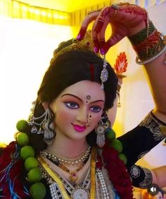 a close up of a woman in costume with jewelry on her neck and hands behind her head