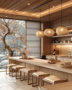 a kitchen with lots of counter space next to a large window and some lights hanging from the ceiling