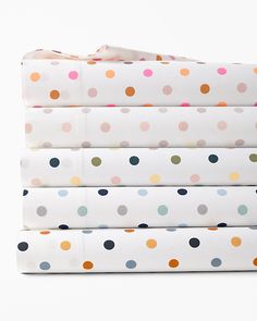 four sheets with multicolored polka dot designs on them are folded up in front of each other