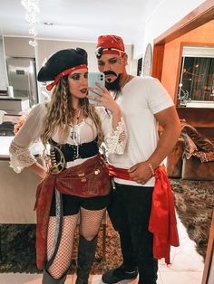 a man and woman in pirate costumes taking a selfie