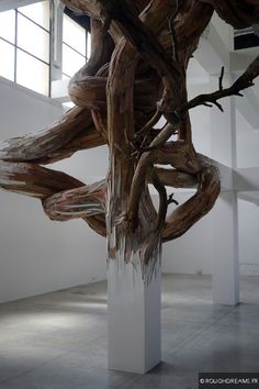 a sculpture made out of branches in a white room