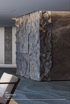 a chair sitting next to a stone wall in an empty room with blue carpeting