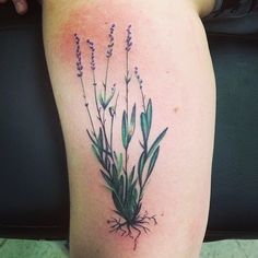 a woman's thigh with flowers and roots on it