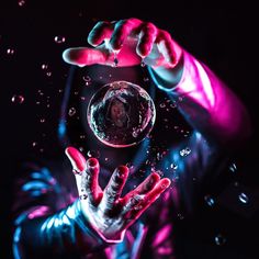 a person holding a wine glass in front of their face with water splashing on it