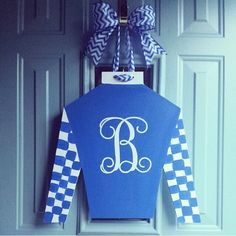 a door hanger with a monogrammed shirt hanging from it's side