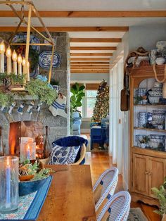 a dining room table and chairs with candles on the top of them in front of a stone fireplace