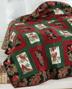 a quilted blanket with red and green flowers on it