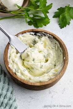 a wooden bowl filled with mashed potatoes and parsley