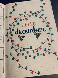 an open notebook with the words hello december written in blue, green and red on it