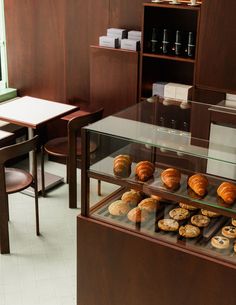 there are many pastries on display in the glass case at the bakery counter,