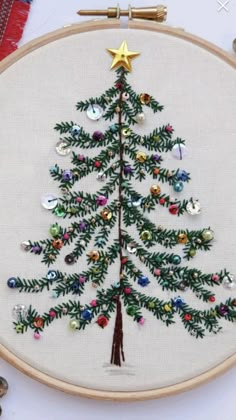 a cross stitch christmas tree with ornaments on it