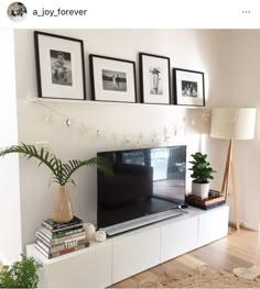 a flat screen tv sitting on top of a white entertainment center in a living room